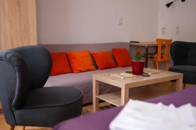a living room with a couch with colorful pillows at Lukas Guest Rooms in Kraków