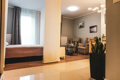 a bedroom with a bed and a living room at Nowe Zabłocie in Kraków