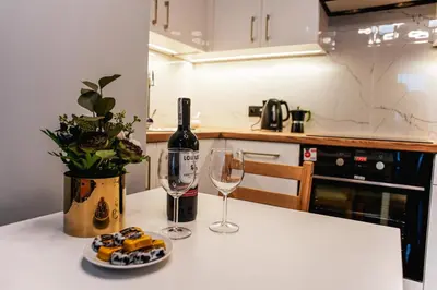 a table with a bottle of wine and two glasses at Nowe Zabłocie in Kraków