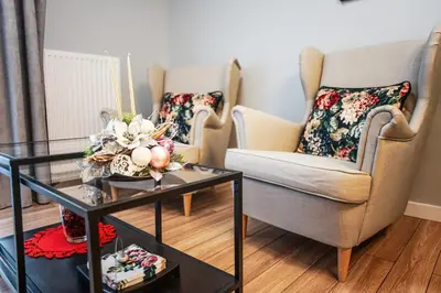 a living room with two chairs and a table at Nowe Zabłocie in Kraków