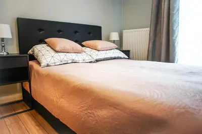 a bedroom with a large bed with two pillows at Nowe Zabłocie in Kraków