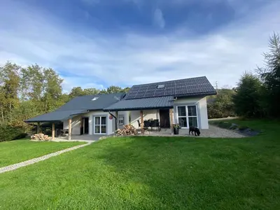 a house with solar panels on the roof at Domki, apartament, pokój, Limanowa in Limanowa