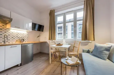 a kitchen and living room with a couch and a table at Solna Atelier in Kraków