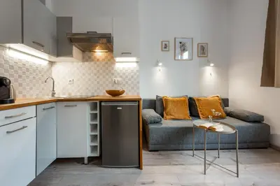 a kitchen and living room with a couch and a table at Solna Atelier in Kraków