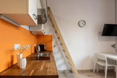 a kitchen with a sink and a clock on the wall at Solna Atelier in Kraków