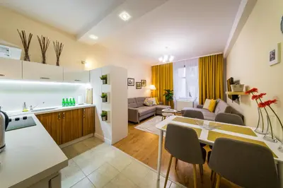 a kitchen and living room with a table and chairs at Apartament Wietora WAWELOFTS in Kraków