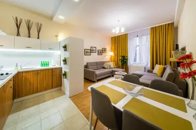 a kitchen and a living room with a dining room table at Apartament Wietora WAWELOFTS in Kraków