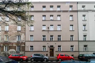 a large building with cars parked in front of it at Apartament Wietora WAWELOFTS in Kraków