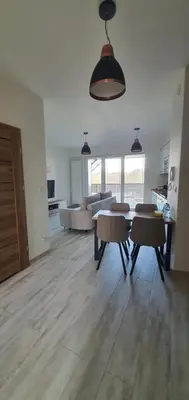 a kitchen and living room with a table and chairs at PIANISSIMO in Kraków