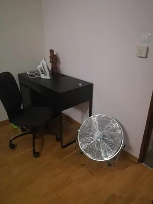 a desk with a fan next to a chair and a fan at Salt Mine Apartment 64m2 in Wieliczka