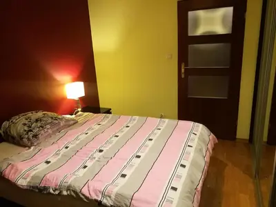 a bedroom with a bed and a lamp and a door at Salt Mine Apartment 64m2 in Wieliczka