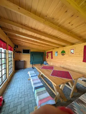 a room with a wooden ceiling with a table and mats at Apartament Przy Potoku in Zubrzyca Górna