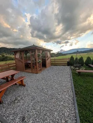 a gazebo with a picnic table and a bench at Apartament Przy Potoku in Zubrzyca Górna