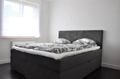 a large bed in a bedroom with a large window at Ludwinowska11 Apartments in Kraków