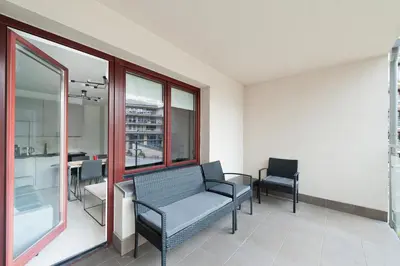 a waiting room with a chair and a table and windows at Ludwinowska11 Apartments in Kraków