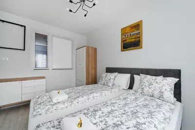 a bedroom with a large bed and a dresser at Ludwinowska11 Apartments in Kraków