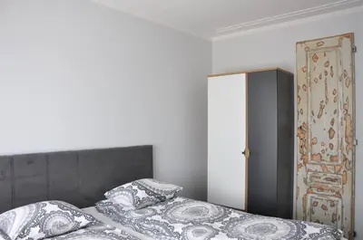 a bedroom with a bed with pillows and an open door at Ludwinowska11 Apartments in Kraków
