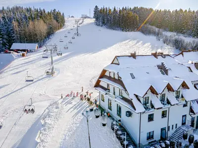 a dining room with tables and chairs and windows at Hotel Kompleks Beskid z basenem i stokiem narciarskim - blisko Babiej Góry in Spytkowice