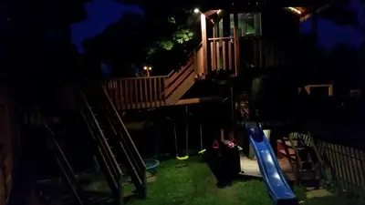 a childrens playground at night with a blue swing at Willa Szarotka in Rabka
