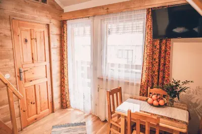 a dining room with a table and a window at Willa Szarotka in Rabka