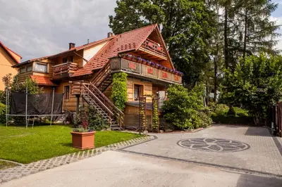 a wooden house with a staircase leading up to it at Willa Szarotka in Rabka