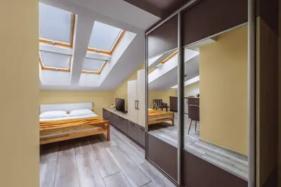 a bedroom with a bed and a tv and windows at Native Apartments Rakowicka 6 in Kraków