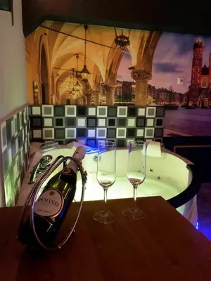 a bottle of wine sitting on a table with two glasses at UNDERGROUND Jacuzzi Rooms in Kraków