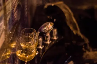 two glasses of white wine sitting on a table at UNDERGROUND Jacuzzi Rooms in Kraków