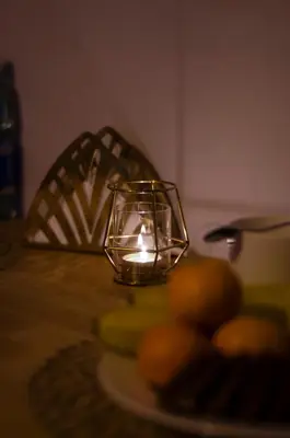 a candle in a glass candle holder on a table at UNDERGROUND Jacuzzi Rooms in Kraków