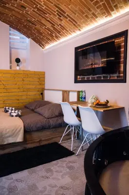 a bedroom with a bed and a table and chairs at UNDERGROUND Jacuzzi Rooms in Kraków