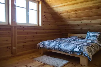 a bedroom with a bed in a log cabin at Wrzosowe Zacisze in Siepraw