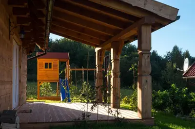 a wooden pergola with a chicken house in the background at Wrzosowe Zacisze in Siepraw
