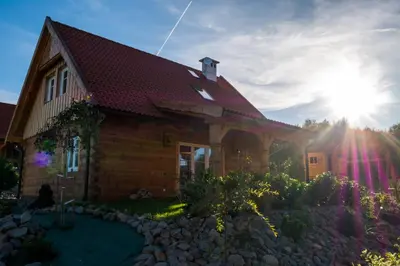 a house with the sun setting behind it at Wrzosowe Zacisze in Siepraw