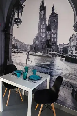 a white table with two chairs and a person in the city at Apartament Turkusowy - Kraków, Kazimierz in Kraków