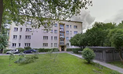 a large white building with cars parked in front of it at Apartament Turkusowy - Kraków, Kazimierz in Kraków