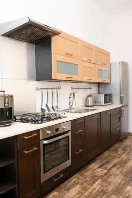 a kitchen with wooden cabinets and a stove top oven at WONDER CRACOW in Kraków