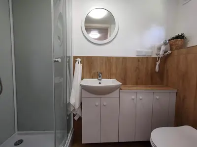 a bathroom with a sink and a shower at Domki Całoroczne - Tarlagowy Bór in Bebło