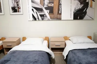two beds in a room with pictures on the wall at Apartment with GARDEN in CITY CENTER in Kraków