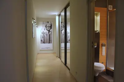 a hallway of a bathroom with a toilet and mirrors at Apartment with GARDEN in CITY CENTER in Kraków