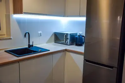 a kitchen with a sink and a stainless steel refrigerator at Mogilska Tower + garaż in Kraków