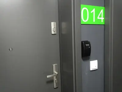 a green exit sign on a door in an elevator at Mogilska Tower + garaż in Kraków
