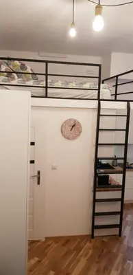 a room with two bunk beds and a clock on a wall at Apartment Lenartowicza in Kraków