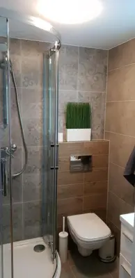 a bathroom with a toilet and a glass shower at Apartment Lenartowicza in Kraków