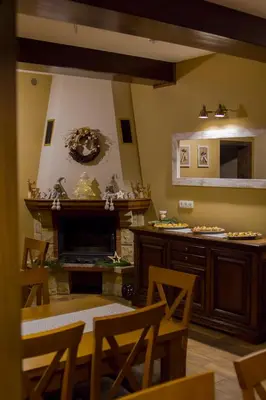 a dining room with a fireplace and a table and chairs at Bacówka na Zadzielu in Laskowa