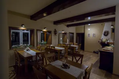 a restaurant with wooden tables and wooden chairs at Bacówka na Zadzielu in Laskowa