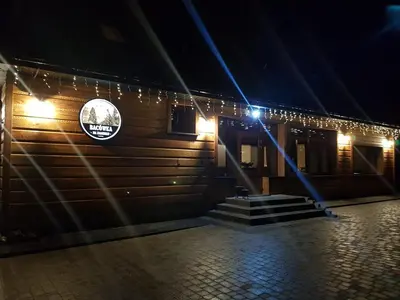 a building with lights on the side of it at night at Bacówka na Zadzielu in Laskowa