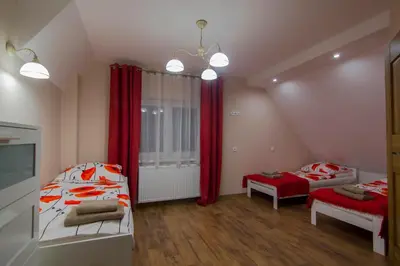 a bedroom with two beds and red curtains at Bacówka na Zadzielu in Laskowa