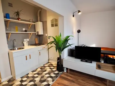 a kitchen with a sink and a tv on a counter at Apartament Mazowiecka 125 in Kraków