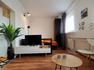 a living room with a tv on a white cabinet at Apartament Mazowiecka 125 in Kraków