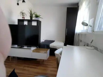 a living room with a tv and a white couch at Apartament Mazowiecka 125 in Kraków